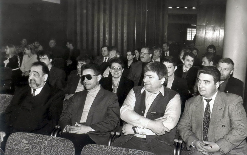 На нейкім сходзе. У кадры відаць таксама Карласа Шэрмана, Славаміра Адамовіча, Уладзіміра Дзюбу, Канстанціна Скуратовіча, Анатоля Лябедзьку, Вольгу Караткевіч, Ірыну Сакалову, Аляксандра Патупу, Андрэя Бастунца, Іосіфа Сярэдзіча, Віктара Івашкевіча ды іншых