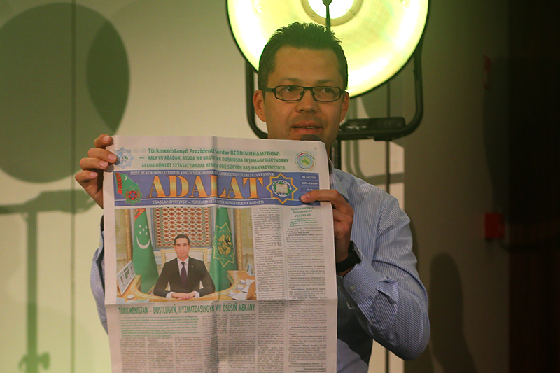 Руслан Мятиев демонстрирует прогосударственную туркменистанскую газету Adalat (в пер. — «Справедливость»). Фото: БАЖ